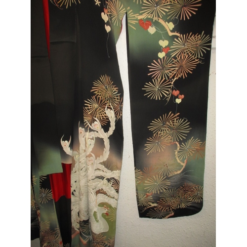 322 - A black silk Japanese kimono. In used condition with a few loose threads and wear. Approximate lengt... 