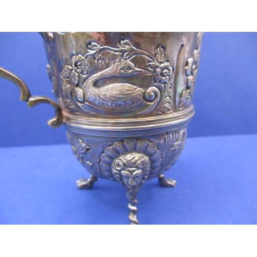 205 - An antique sterling silver cream jug, Chester Hallmark, repousse hunting scene decoration, in good u... 