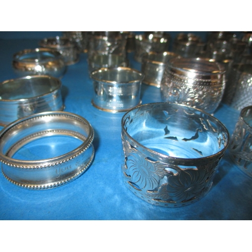 166 - A large quantity of antique and later sterling silver napkin rings, to include some pairs, all in go... 