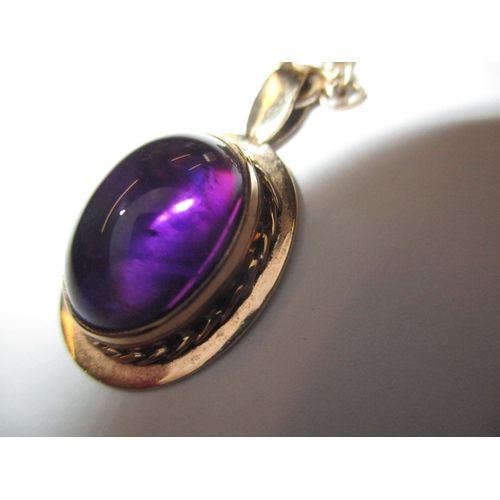 68 - A 9ct yellow gold necklace the pendant set with a cabochon amethyst, approx. chain linear length 48c... 