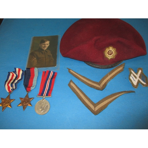 247 - A 1945 dated British Airborne RASC maroon Kangol beret with cap badge, medals and photo, all in used... 