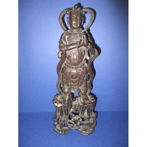 236 - An antique cast bronze figure of an oriental deity on carved wood stand, approx. height 26cm, having... 