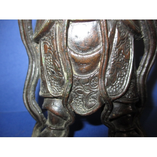 236 - An antique cast bronze figure of an oriental deity on carved wood stand, approx. height 26cm, having... 