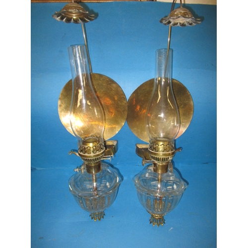 293 - Two vintage oil burning wall lights, with glass reservoirs and brass mounts, having use-related mark... 