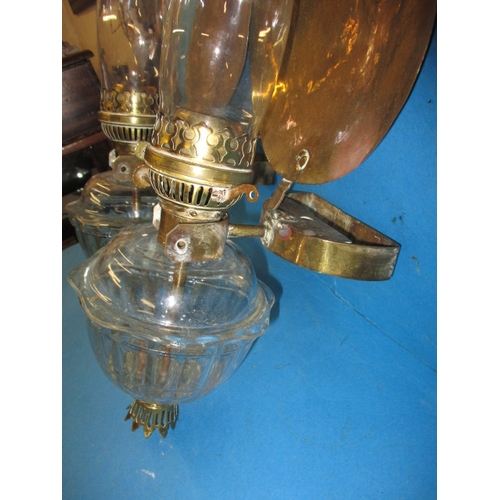 293 - Two vintage oil burning wall lights, with glass reservoirs and brass mounts, having use-related mark... 