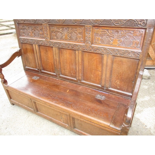 329 - An antique mixed wood box settle with carved back panel, with later upholstered cushion, approx. len... 