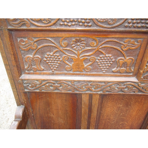 329 - An antique mixed wood box settle with carved back panel, with later upholstered cushion, approx. len... 