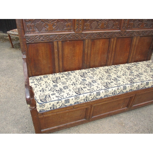 329 - An antique mixed wood box settle with carved back panel, with later upholstered cushion, approx. len... 