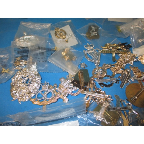 11 - A large quantity of British military stay-bright badges, some in original packaging