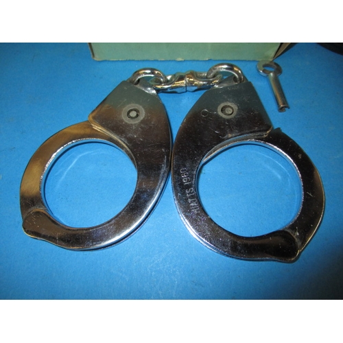 33 - Two pairs of police handcuffs, one set boxed dated 1960, both with leather holders and keys