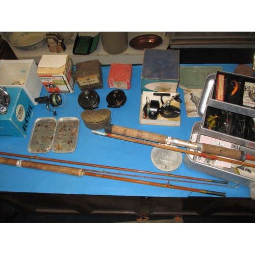 63 - A quantity of vintage fishing tackle, to include boxed reels and cane rods and a brass bait box, all... 