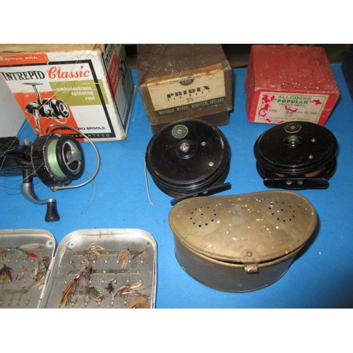 63 - A quantity of vintage fishing tackle, to include boxed reels and cane rods and a brass bait box, all... 