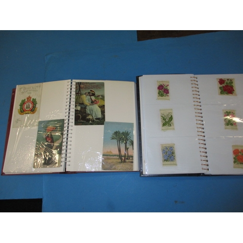 110 - An album of WW1 and later post cards and an album of silk cigarette cards all in preowned condition.