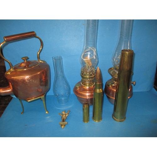 121 - A parcel of vintage copper and brass items, to include military shell cases and oil lamps, all in go... 