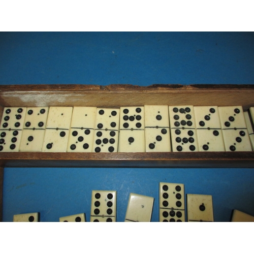 167 - A vintage set of double 9s dominos, a complete set constructed of bone and ebony, housed in period p... 