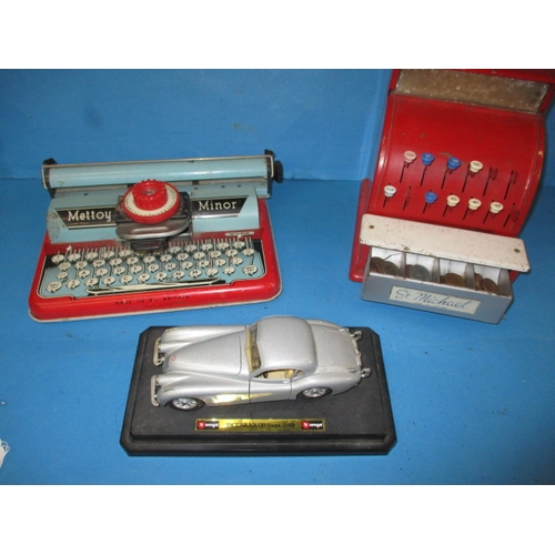 202 - A child’s Mettoy tin-plate typewriter, a child’s toy shop till  and a die-cast model car, all in use... 