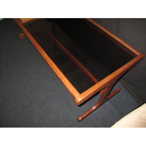 285 - A 1970s teak g-plan coffee table with tiled and smoked glazed top, approx. size: L 121cm W 50cm H 45... 