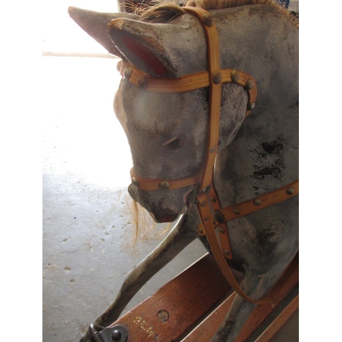 322 - A vintage hand carved rocking horse on pine safety rocker. Approximate length 107cm. In useable cond... 