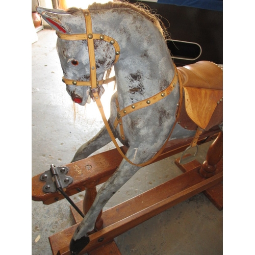 322 - A vintage hand carved rocking horse on pine safety rocker. Approximate length 107cm. In useable cond... 