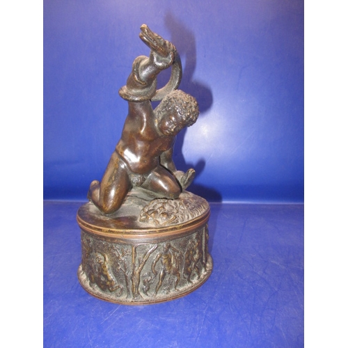 256 - An early 20th century two piece bronze sculpture of a man wrestling 2 snakes and sitting on a lion, ... 