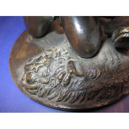 256 - An early 20th century two piece bronze sculpture of a man wrestling 2 snakes and sitting on a lion, ... 