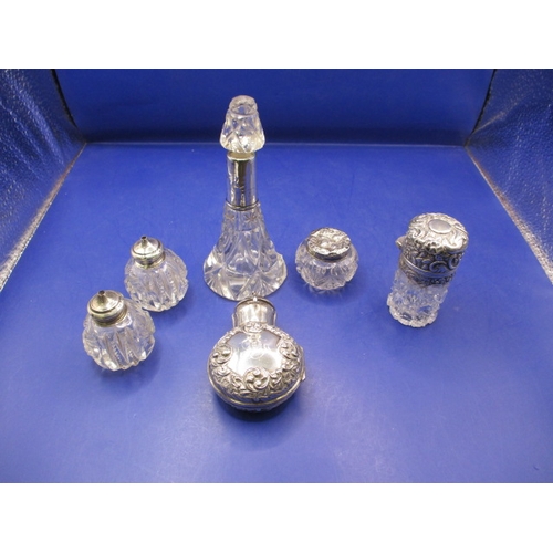 242 - A parcel of silver topped bottles and jars, to include a cased smelling salts bottle, all with gener... 