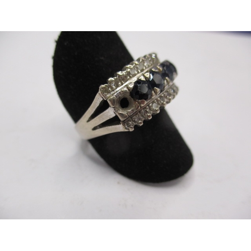 28 - A 14k white gold diamond and sapphire ring, approx. ring size ‘O’, approx. weight 5.4g, having one s... 