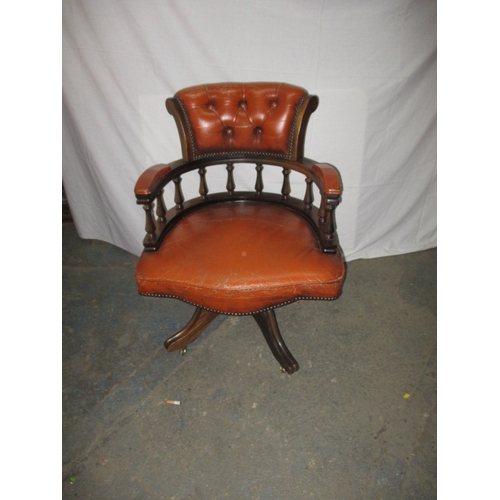 317 - A rust colour leather office chair, having a small split to one fold and general use related marks