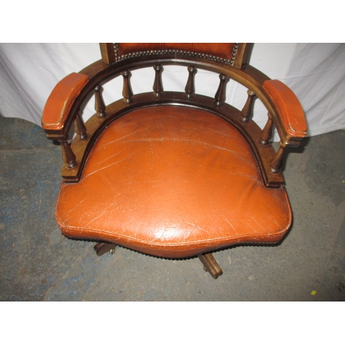 317 - A rust colour leather office chair, having a small split to one fold and general use related marks