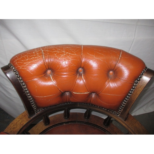 317 - A rust colour leather office chair, having a small split to one fold and general use related marks