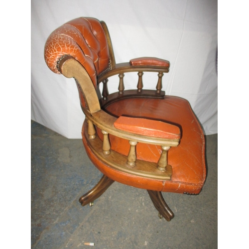 317 - A rust colour leather office chair, having a small split to one fold and general use related marks