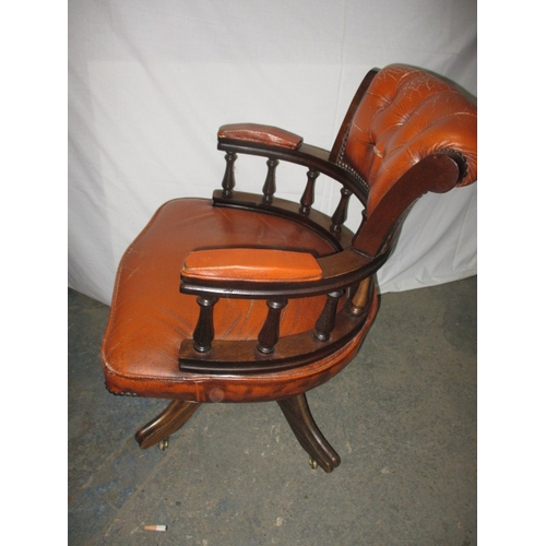 317 - A rust colour leather office chair, having a small split to one fold and general use related marks