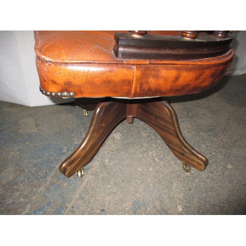 317 - A rust colour leather office chair, having a small split to one fold and general use related marks