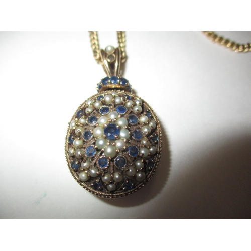 78 - A 9ct yellow gold necklace chain and pendant, the pendant set with pale blue sapphires and seed pear... 