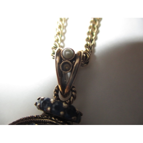 78 - A 9ct yellow gold necklace chain and pendant, the pendant set with pale blue sapphires and seed pear... 