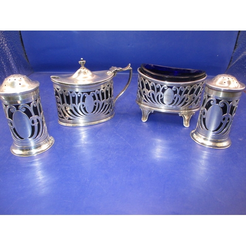 235 - An Edwardian sterling silver 4 piece cruet set, Chester hall mark, having original blue glass liners... 