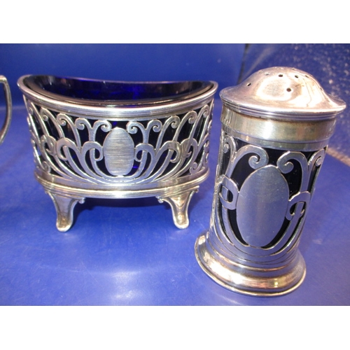 235 - An Edwardian sterling silver 4 piece cruet set, Chester hall mark, having original blue glass liners... 