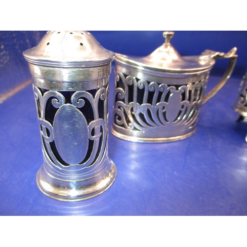 235 - An Edwardian sterling silver 4 piece cruet set, Chester hall mark, having original blue glass liners... 