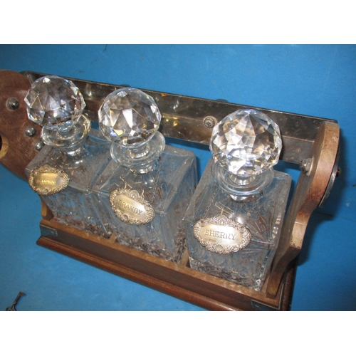 333 - An early 20th century 3 bottle tantalus, having sterling silver drinks labels, key and lead crystal ... 