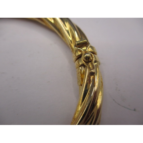 62 - A 750 yellow gold bangle, approx. weight 13g, in useable pre-owned condition with working clasp