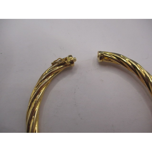 62 - A 750 yellow gold bangle, approx. weight 13g, in useable pre-owned condition with working clasp