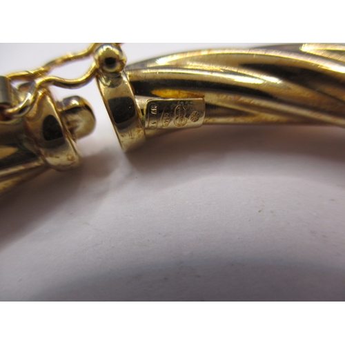 62 - A 750 yellow gold bangle, approx. weight 13g, in useable pre-owned condition with working clasp