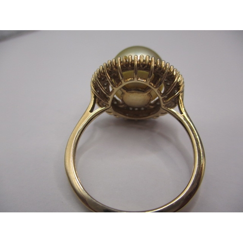 10 - A 9ct yellow gold dress ring with central pearl surrounded by diamonds, approx. ring size ‘R+’, appr... 