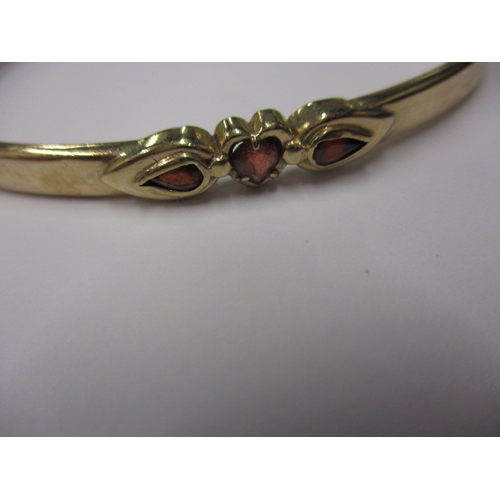 80 - A 9ct yellow gold bangle with 3 garnets, approx. weight 8.4g, in useable pre-owned condition with on... 