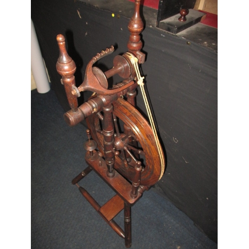 284 - An antique mahogany spinning wheel, in working order, having general use-related marks