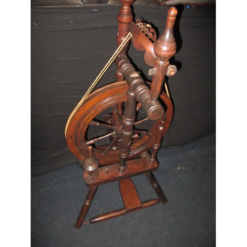 284 - An antique mahogany spinning wheel, in working order, having general use-related marks