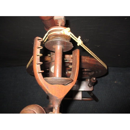 284 - An antique mahogany spinning wheel, in working order, having general use-related marks