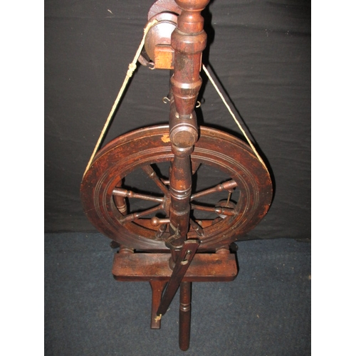 284 - An antique mahogany spinning wheel, in working order, having general use-related marks