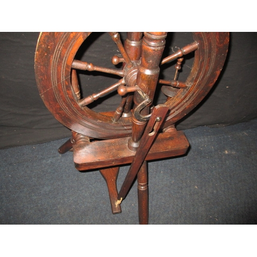 284 - An antique mahogany spinning wheel, in working order, having general use-related marks