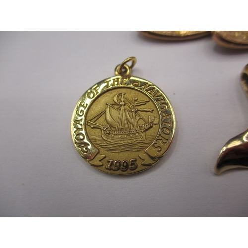 87 - Two Tiffany and Co 585 gold cruise ship medallions, a gold whale tail pendant marked 14k and a 9ct g... 